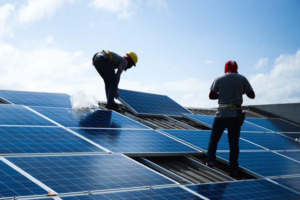 Installateurs en pleine installation de panneaux solaires sur un toit