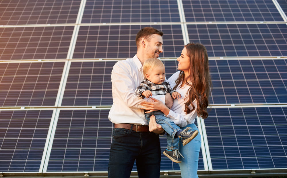 famille heureuse devant l'installation de ses panneaux solaires