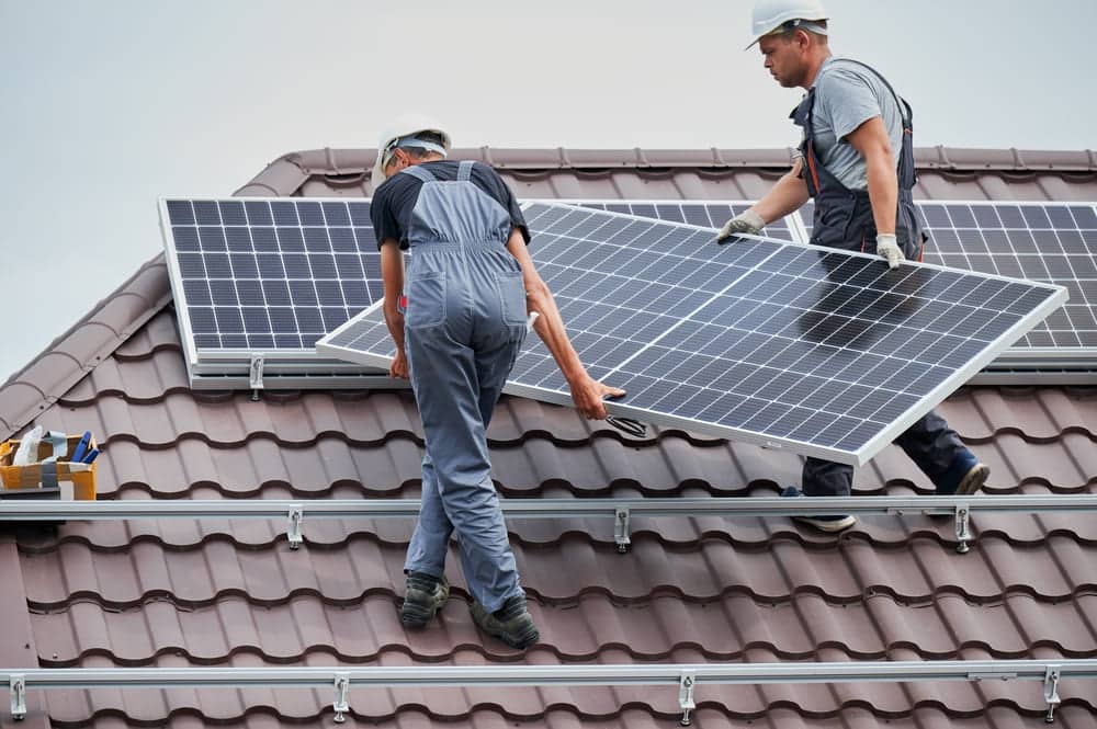 Installateurs qui installant des panneaux solaires