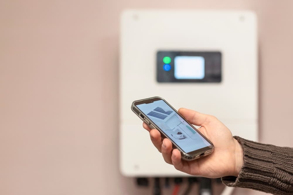 Électricien professionnel configurant régulateur MPPT dans armoire électrique solaire avec ordinateur portable
