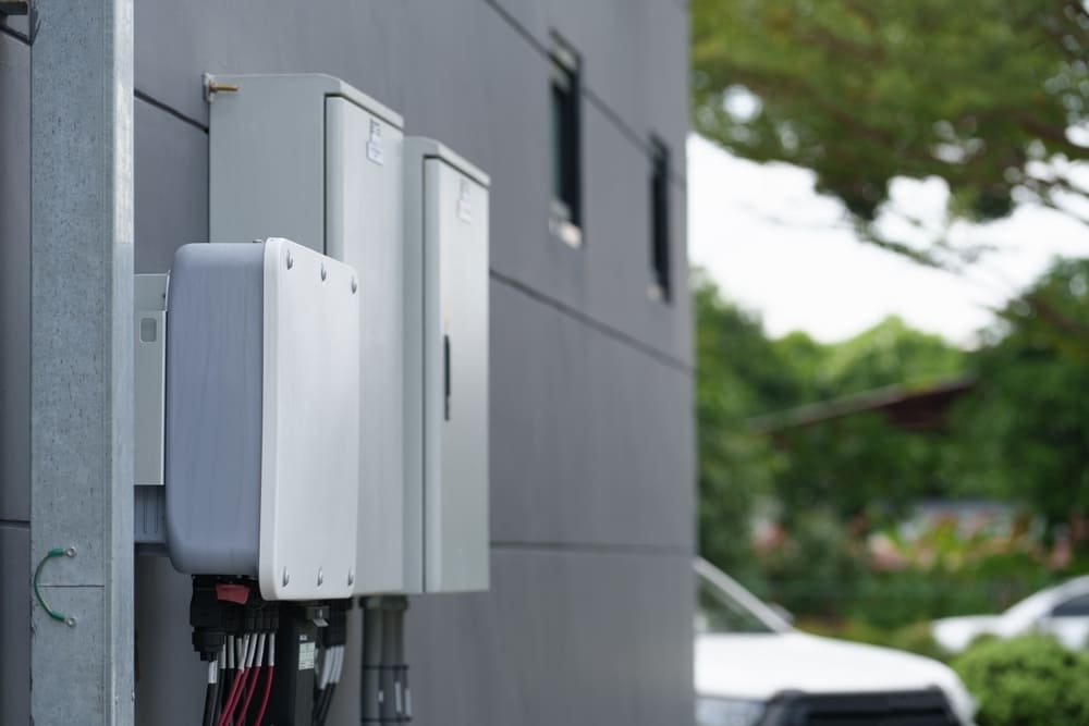 Techniciens professionnels installant des panneaux solaires photovoltaïques sur toiture inclinée pour système avec batterie