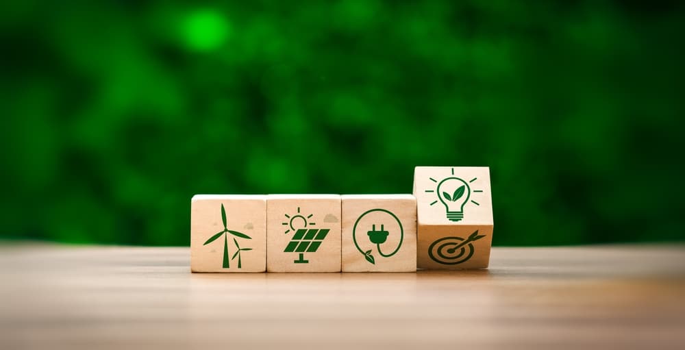 Cubes en bois avec symboles d'énergies renouvelables - éolien, solaire, électrique et objectifs écologiques durables
