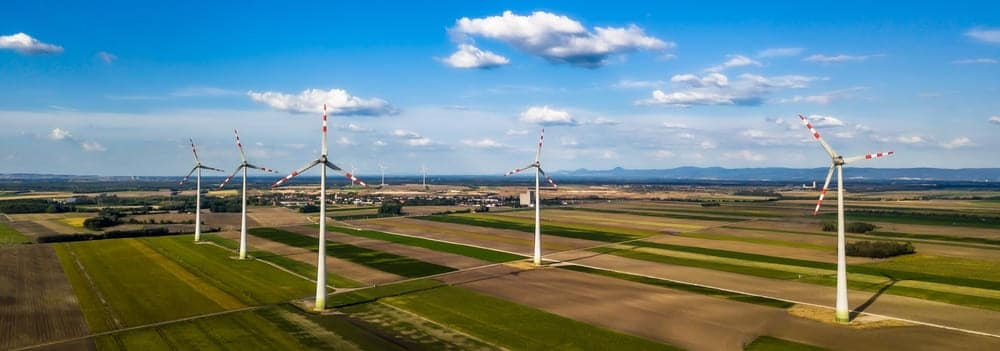 Parc éolien pour production d'électricité verte renouvelable Enercoop dans paysage rural agricole