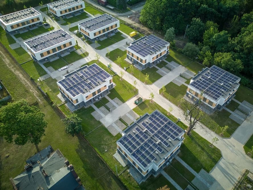 Maison individuelle avec panneaux photovoltaïques installés sur toiture en tuiles rouges dans zone résidentielle PLU