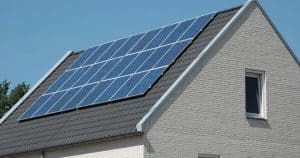 Installation photovoltaïque 9 kW avec panneaux solaires sur toiture inclinée en tuiles grises de maison moderne