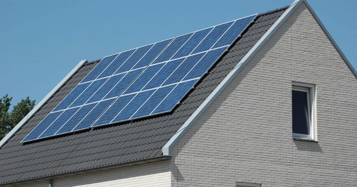 Installation photovoltaïque 9 kW avec panneaux solaires sur toiture inclinée en tuiles grises de maison moderne