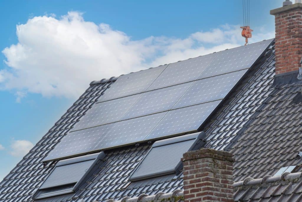 Panneaux solaires photovoltaïques 3 kW intégrés sur toiture en ardoise avec fenêtres de toit et cheminée