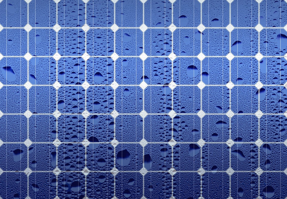 Gros plan sur les cellules d'un panneau solaire recouvertes de gouttes d'eau illustrant la résistance aux intempéries