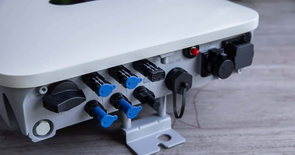 Vue détaillée des connecteurs et ports d'un onduleur hybride solaire avec entrées MC4 et connexions batterie