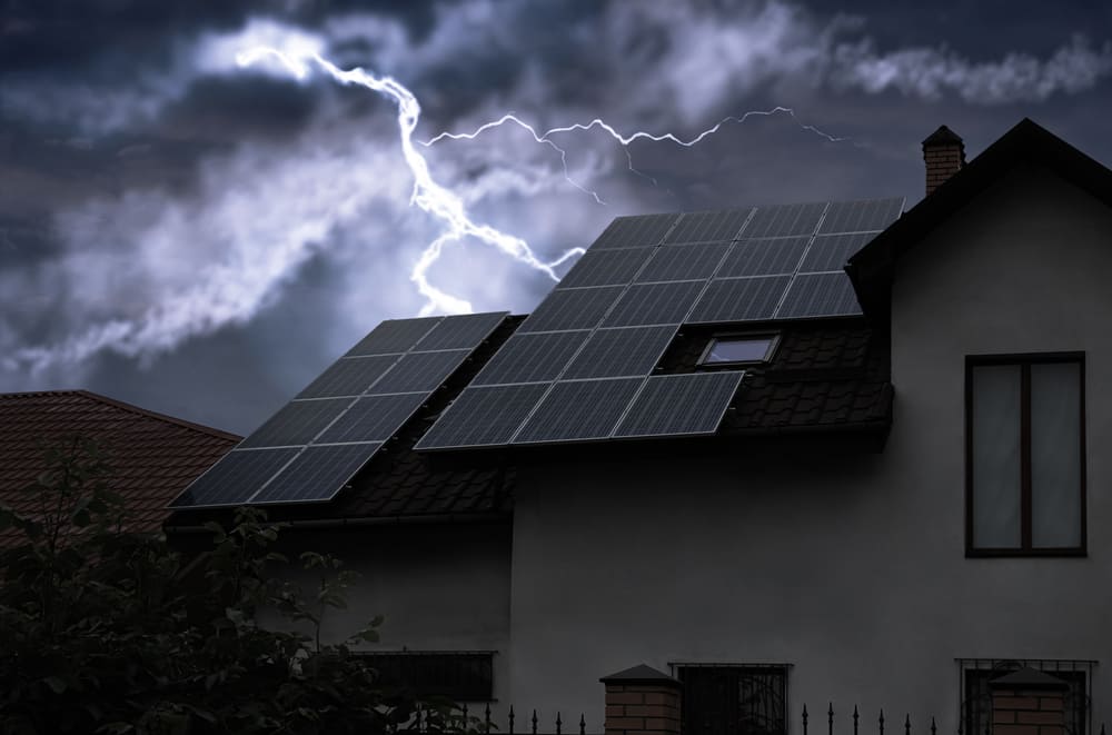 Maison équipée de panneaux solaires photovoltaïques sur le toit pendant un orage avec éclair de foudre