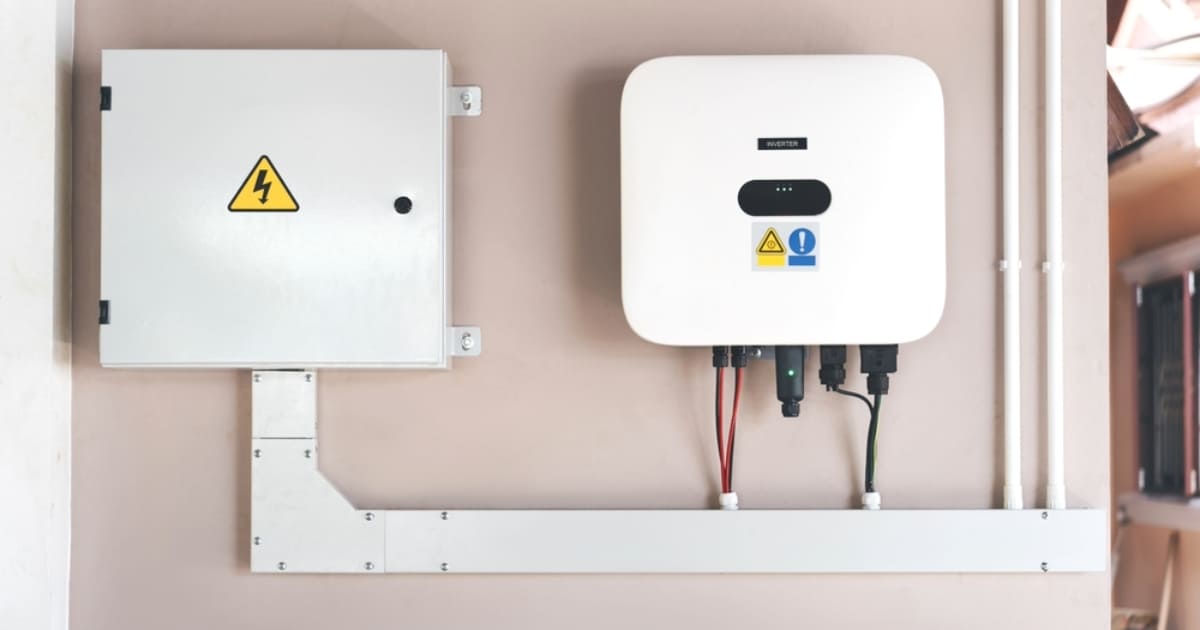 Onduleur solaire et coffret de protection électrique installés sur un mur pour une installation photovoltaïque résidentielle