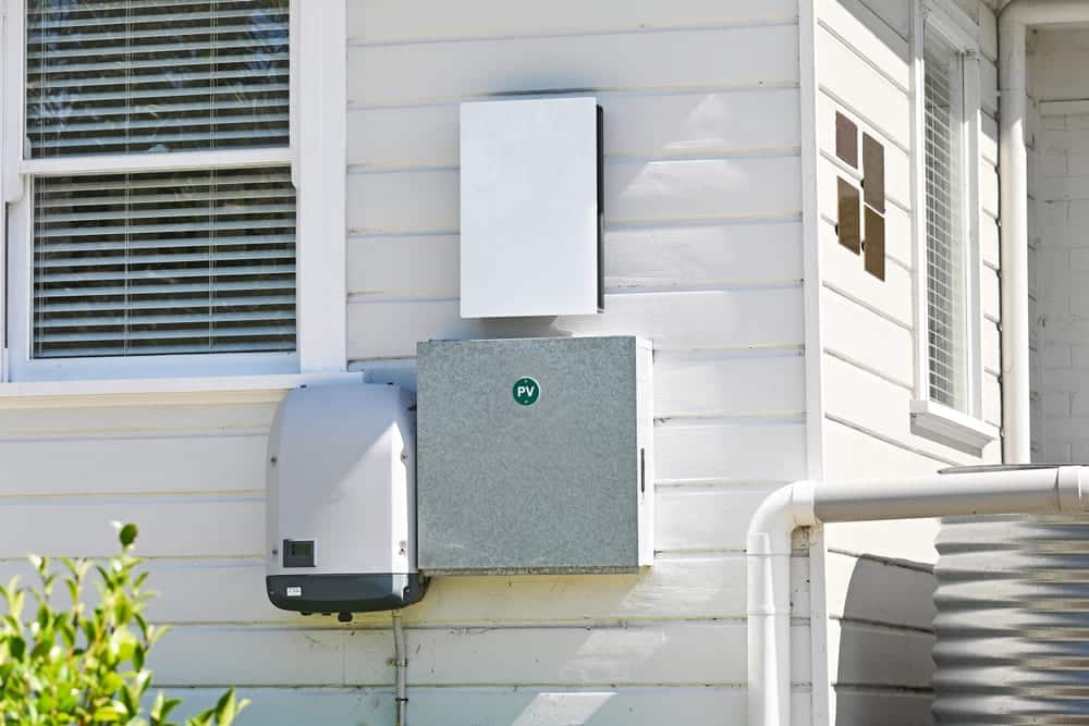 Onduleur solaire et coffrets de protection PV installés en extérieur sur la façade d'une maison