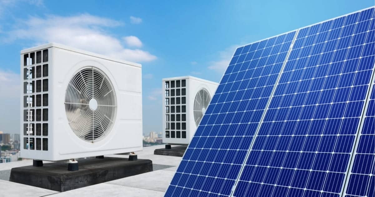 Panneaux solaires photovoltaïques installés à côté d'unités de climatisation sur une toiture terrasse