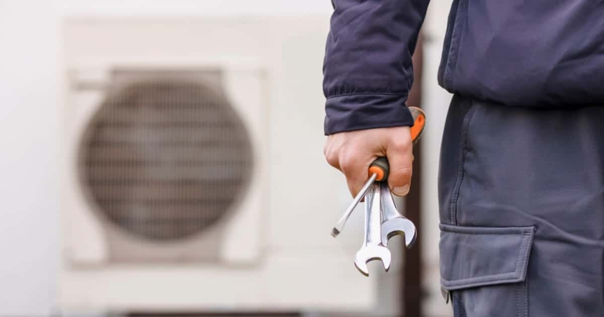 Technicien équipé d'outils prêt à intervenir sur une pompe à chaleur pour vérifier son dimensionnement