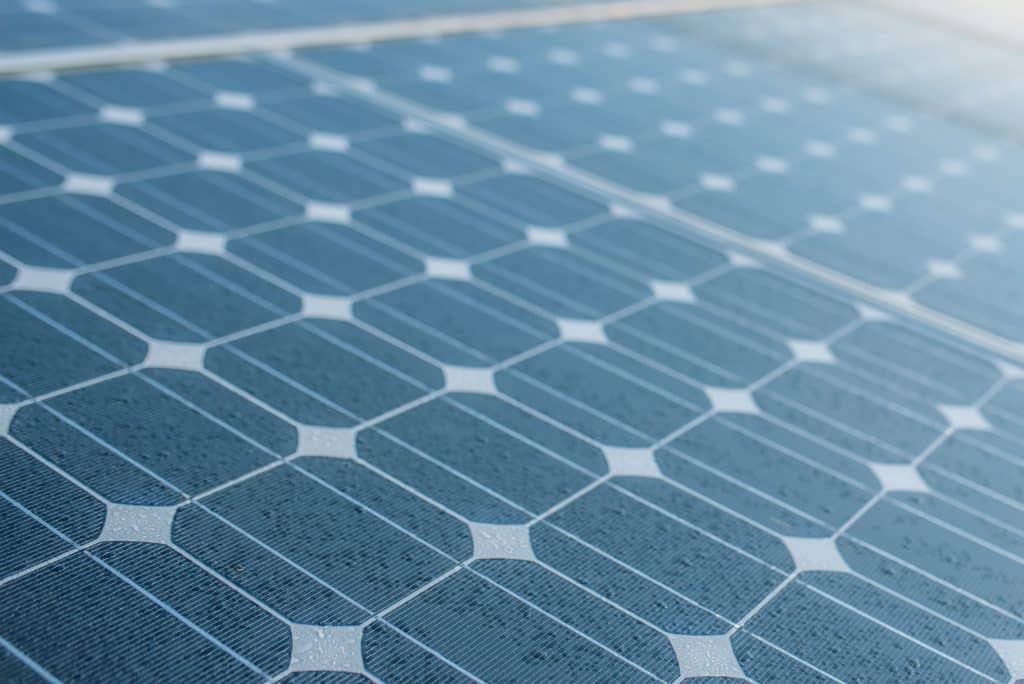 Vue macro de cellules photovoltaïques polycristallines recouvertes de gouttes d'eau illustrant la résistance des meilleurs panneaux solaires