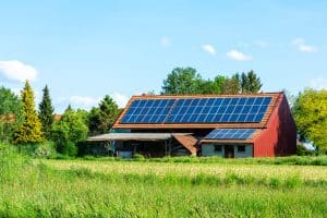Maison de campagne avec panneaux solaires reliés à une batterie solaire
