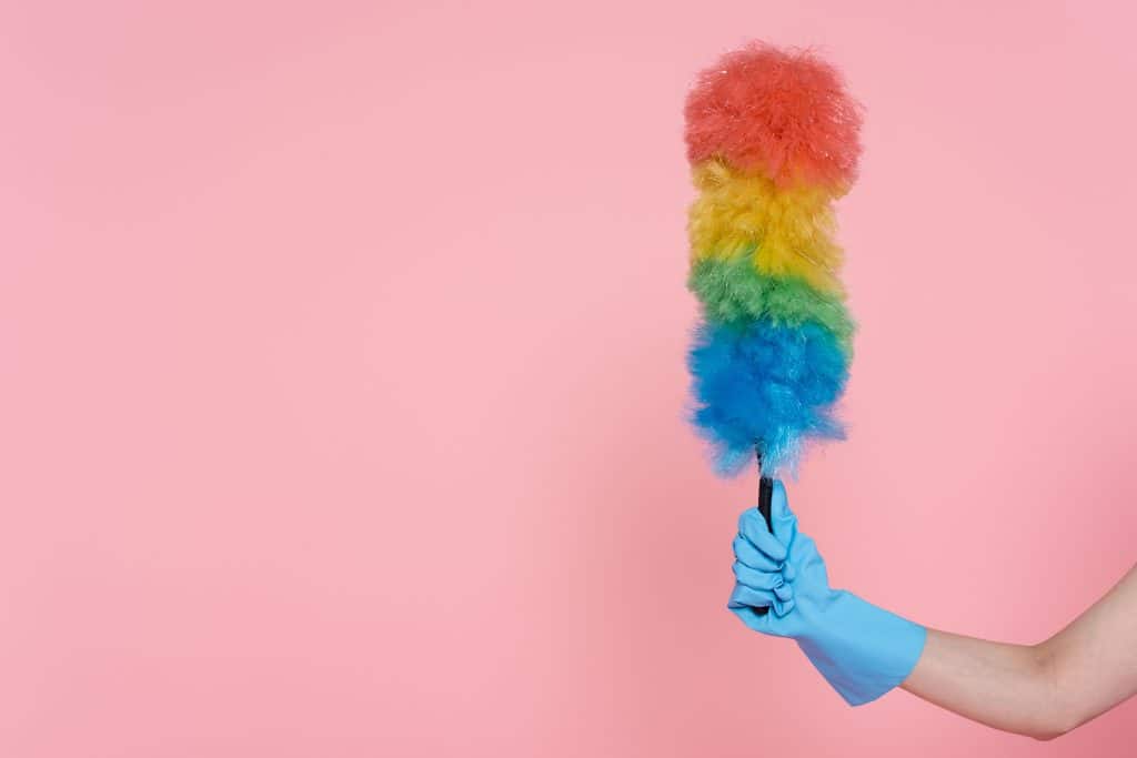 Main gantée tenant un plumeau symbolisant l'entretien régulier nécessaire pour prolonger la durée de vie d'une batterie solaire gel