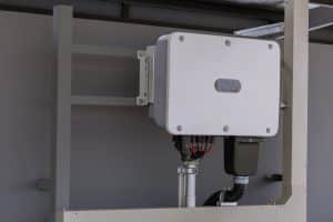 Onduleur solaire blanc installé dans un local technique pour la conversion d'énergie photovoltaïque