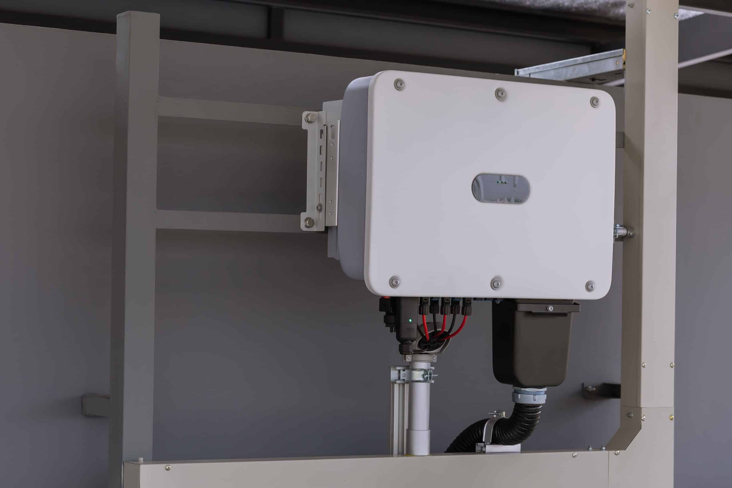 Onduleur solaire blanc installé dans un local technique pour la conversion d'énergie photovoltaïque