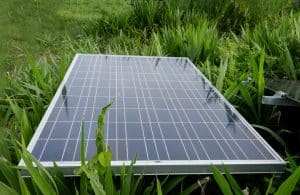 Panneau solaire posé au sol dans un jardin idéal pour une installation plug and play avec micro-onduleur TSUN ou Hoymiles