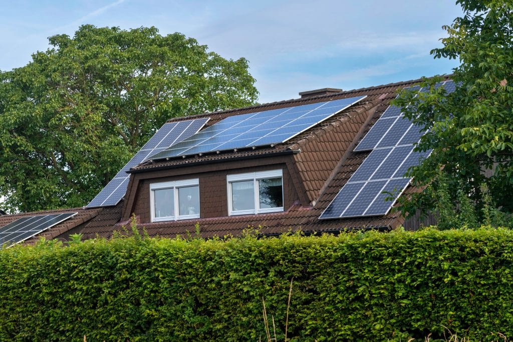  Panneaux solaires disposés sur plusieurs pans de toiture avec différentes orientations illustrant l'importance de la distance entre les modules
