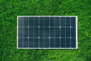 Vue de dessus d'un panneau solaire posé sur une pelouse verte idéal pour un kit solaire plug and play facile à installer